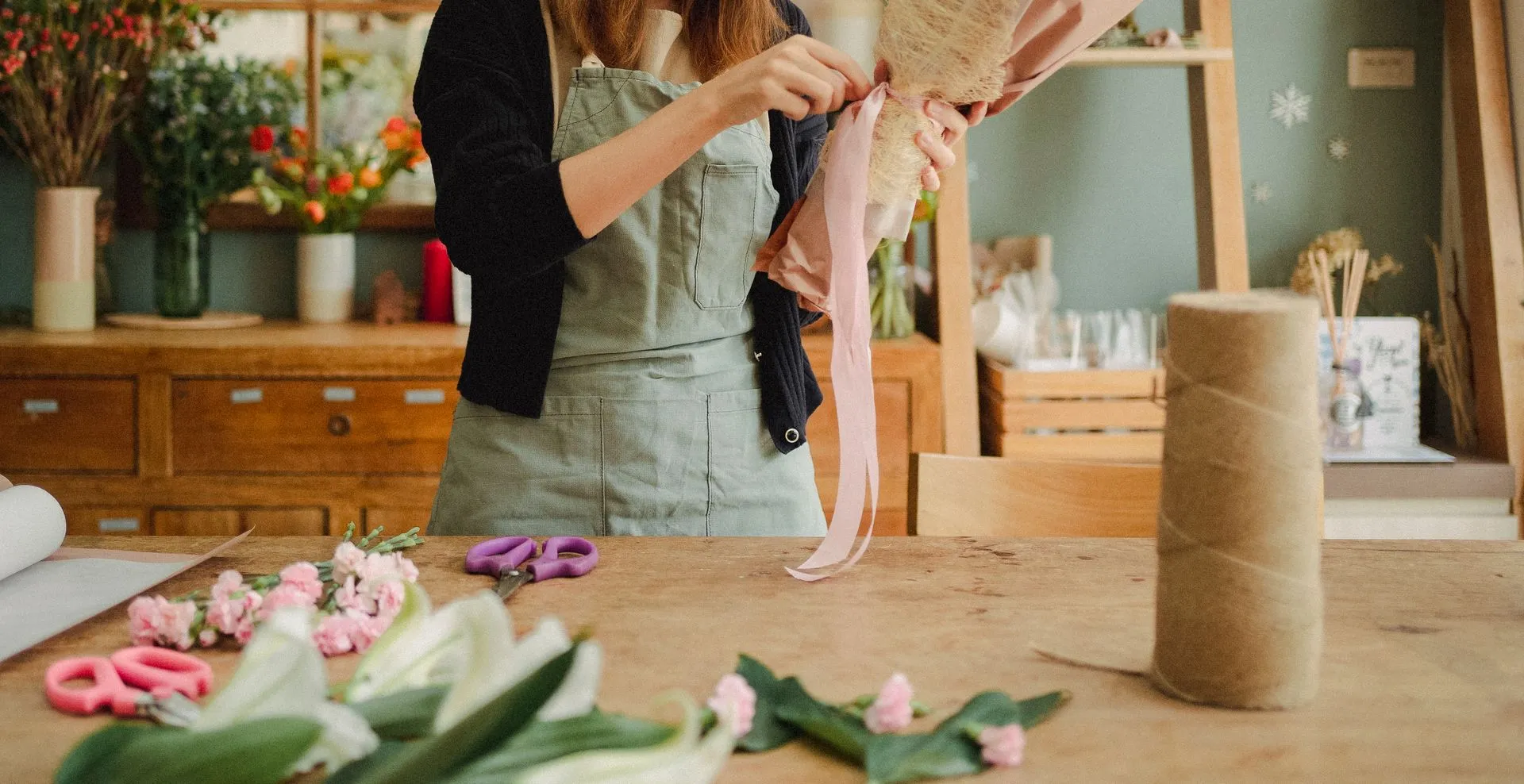 Ribbon being tied around a finished bouquet