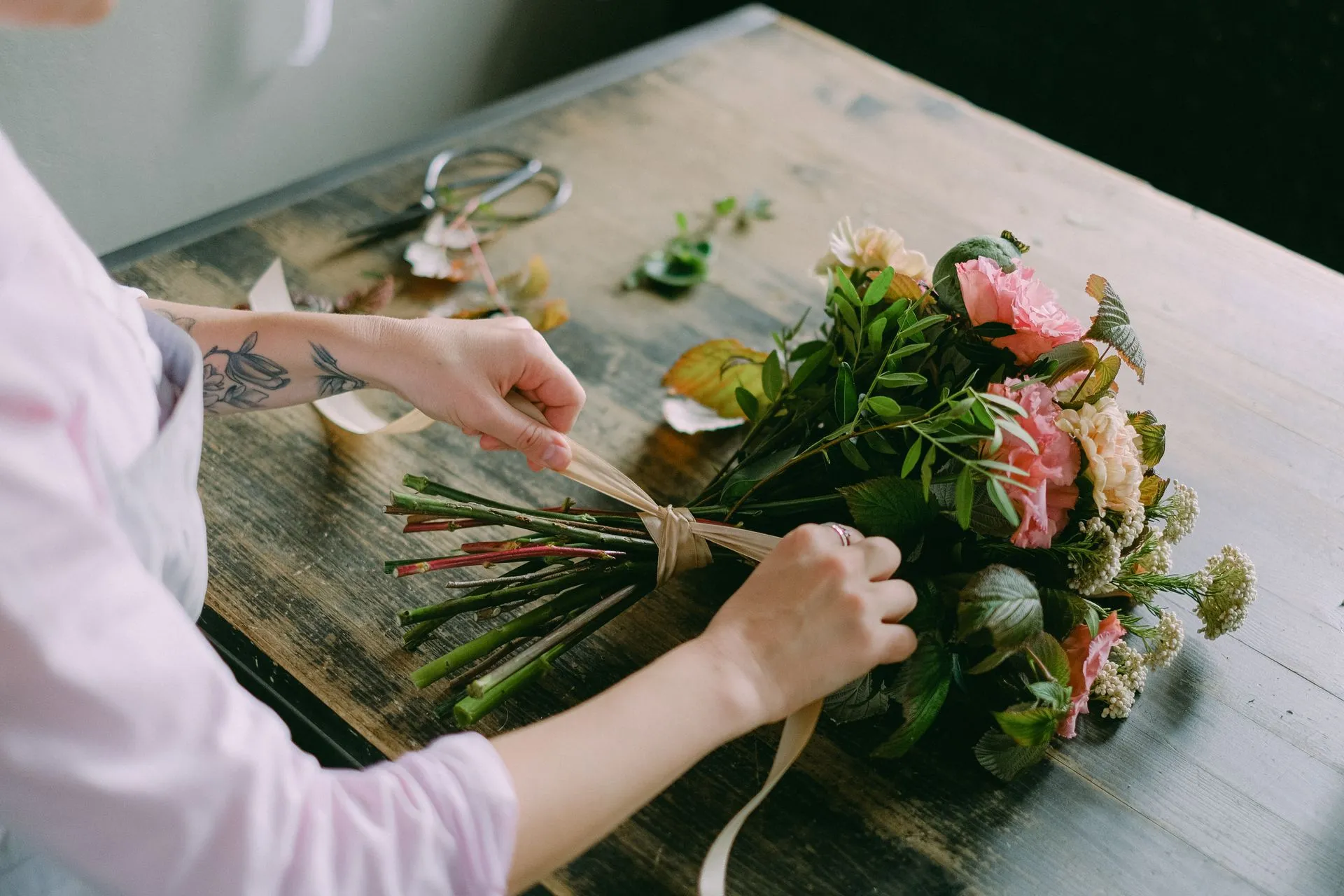 Stems being cut and tied by hand into a fresh bouquet